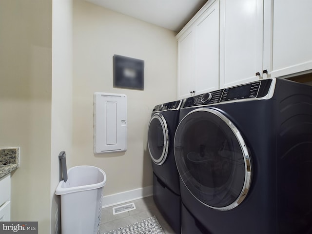 laundry area featuring light tile patterned flooring, cabinets, and washing machine and clothes dryer