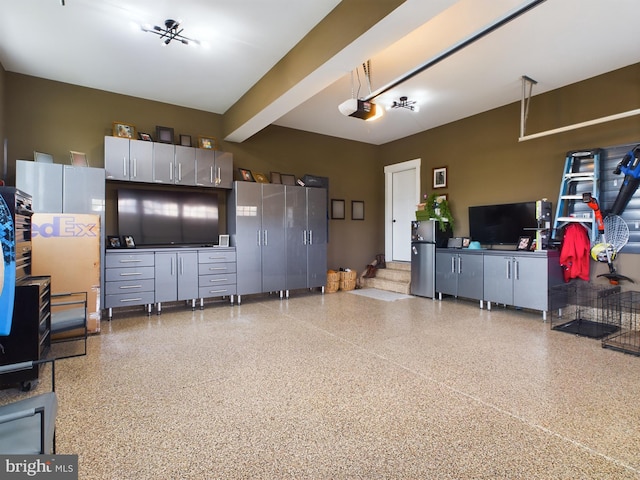 garage featuring a garage door opener and stainless steel fridge