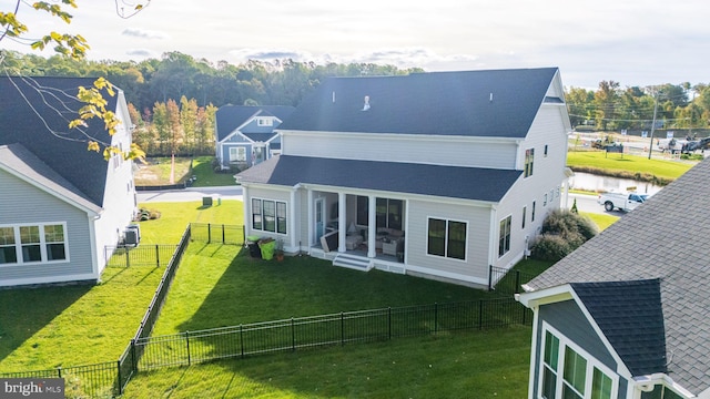 back of property featuring a sunroom and a lawn