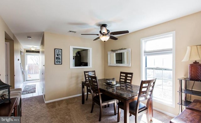 carpeted dining space with ceiling fan