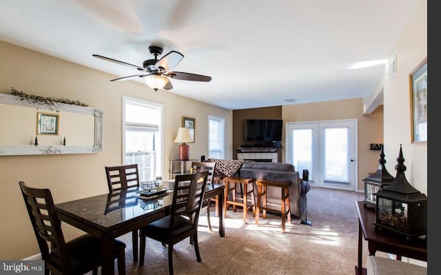 dining room with carpet floors, a wood stove, and ceiling fan