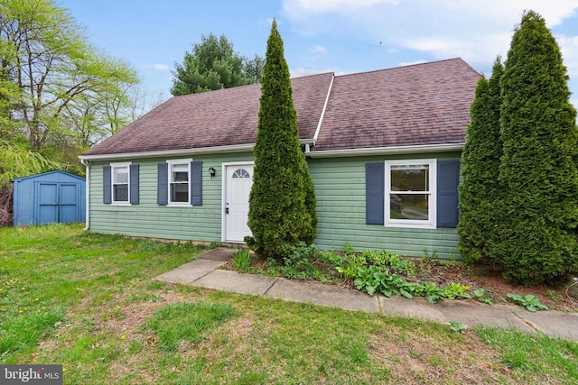 view of front of house with a shed and a front yard