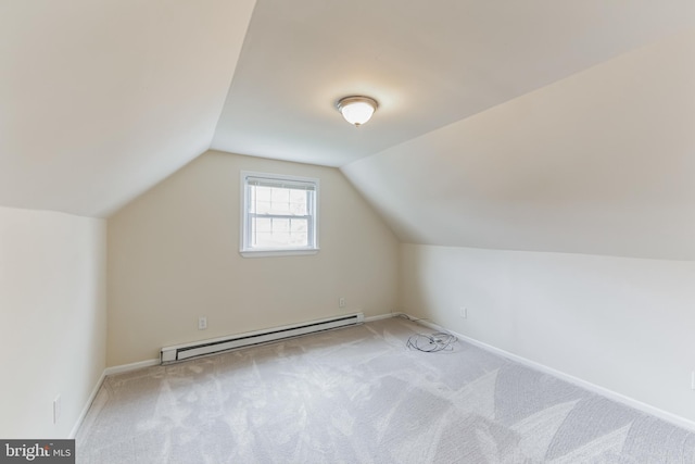 additional living space with a baseboard radiator, vaulted ceiling, and light carpet