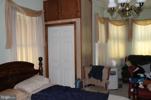 bedroom featuring a closet, carpet floors, and a chandelier