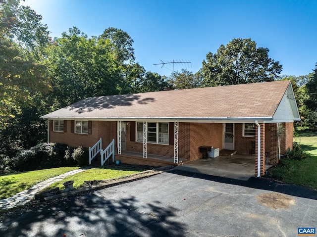 ranch-style home with a front lawn and a carport