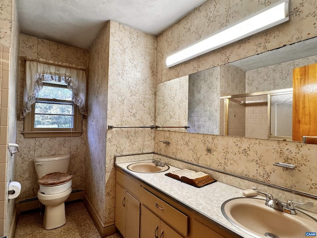 bathroom featuring toilet, a baseboard heating unit, vanity, and a shower with door