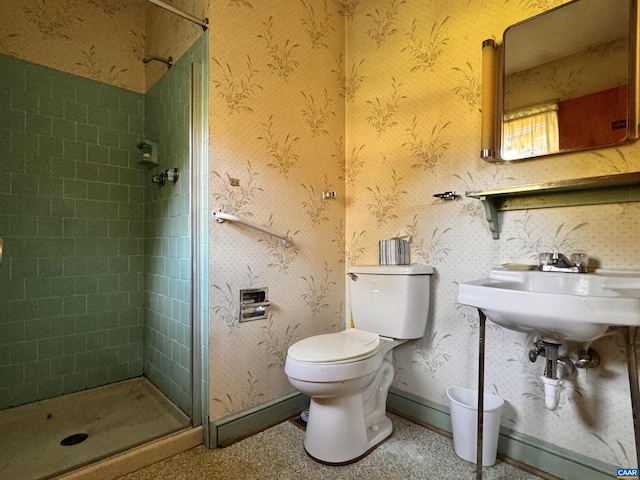 bathroom featuring a sink, toilet, and a shower stall