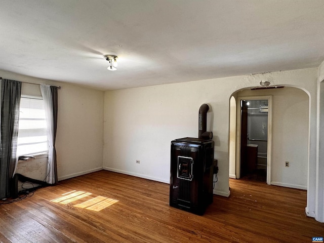 interior space featuring arched walkways, baseboards, and wood finished floors