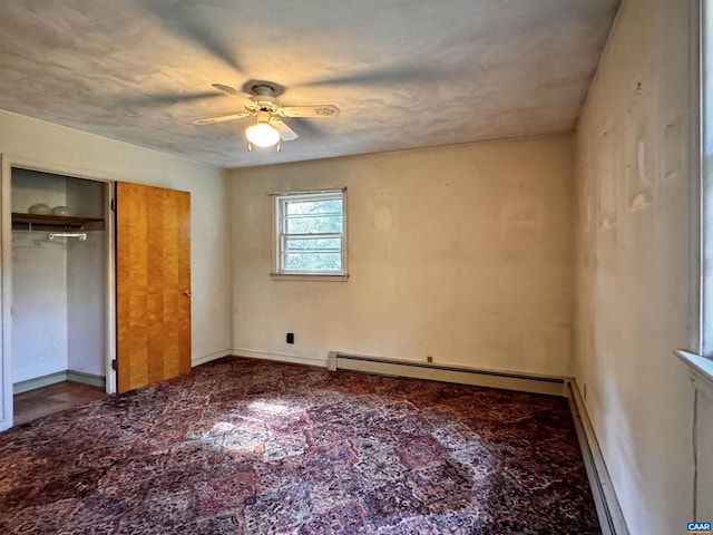 unfurnished bedroom featuring a closet, a baseboard heating unit, and ceiling fan