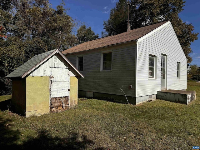 view of property exterior with a shed and a lawn