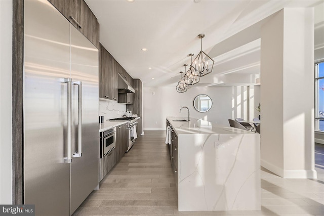 kitchen with sink, appliances with stainless steel finishes, a wealth of natural light, and a kitchen island with sink