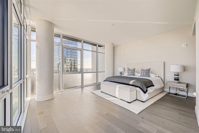 bedroom with multiple windows, hardwood / wood-style flooring, and floor to ceiling windows