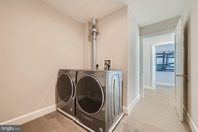 laundry area with light hardwood / wood-style flooring and independent washer and dryer