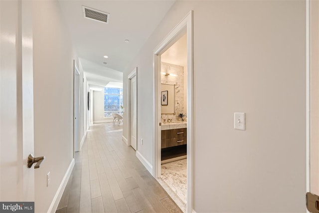 hall with sink and light hardwood / wood-style floors