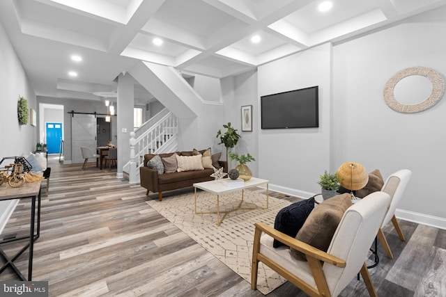 living room with coffered ceiling, beamed ceiling, light hardwood / wood-style flooring, and a barn door