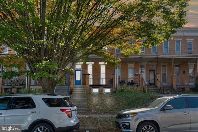 townhome / multi-family property featuring covered porch