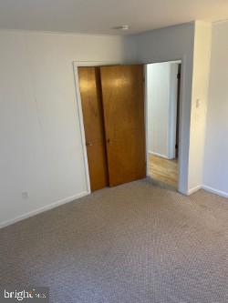 unfurnished bedroom with a closet and carpet flooring