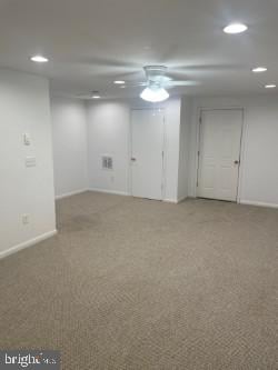 basement featuring ceiling fan and carpet flooring