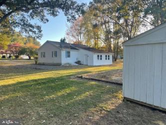 view of home's exterior with a yard and a shed