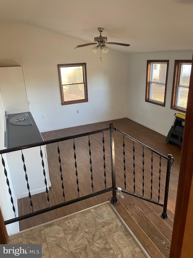 stairs featuring wood-type flooring, vaulted ceiling, and ceiling fan