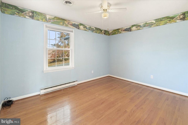 empty room featuring a baseboard heating unit, hardwood / wood-style flooring, and ceiling fan