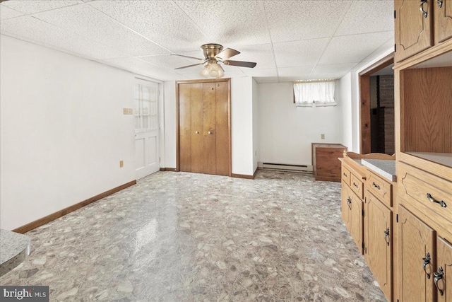 unfurnished bedroom with baseboard heating, a paneled ceiling, light colored carpet, and ceiling fan