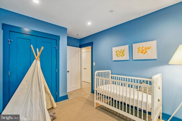 carpeted bedroom with a closet and a crib