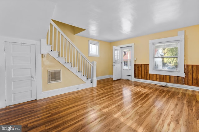 entrance foyer with a wealth of natural light, hardwood / wood-style floors, and wood walls