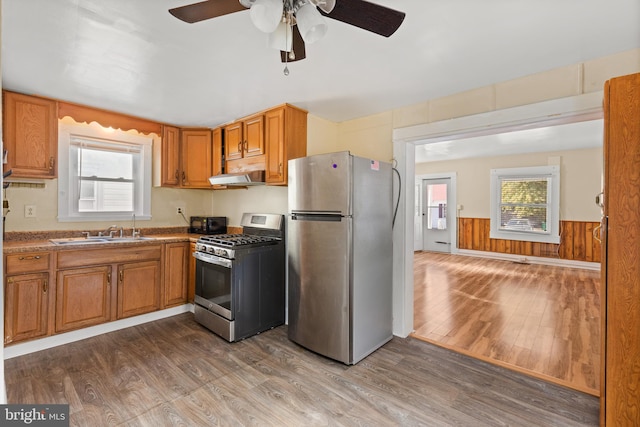 kitchen featuring appliances with stainless steel finishes, a wealth of natural light, exhaust hood, and dark hardwood / wood-style floors