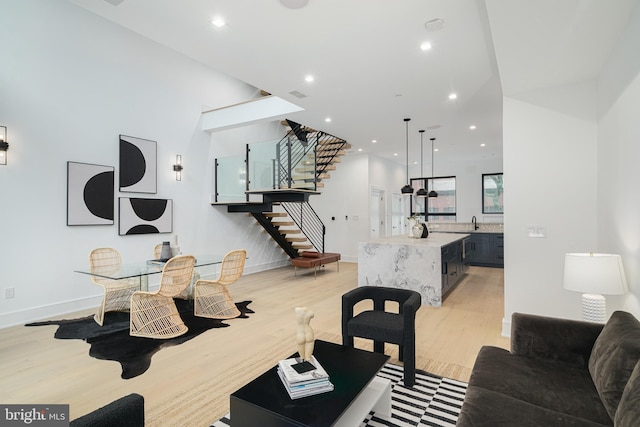 living room with light hardwood / wood-style flooring and a towering ceiling