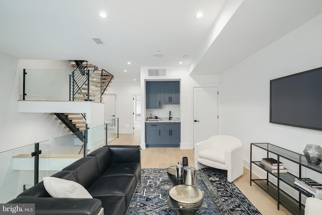 living room with light hardwood / wood-style flooring and sink