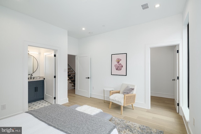 bedroom featuring ensuite bathroom and light wood-type flooring