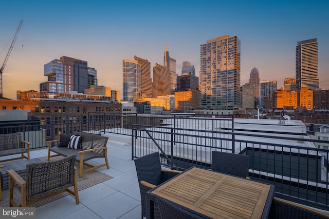 patio terrace at dusk with outdoor lounge area and a balcony