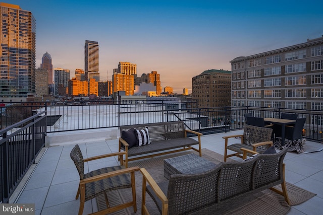 patio terrace at dusk with an outdoor hangout area and a balcony