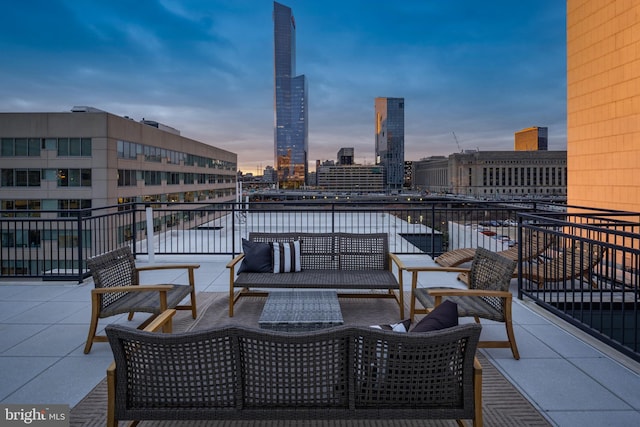 patio terrace at dusk featuring a balcony and outdoor lounge area