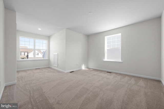 unfurnished room featuring light carpet