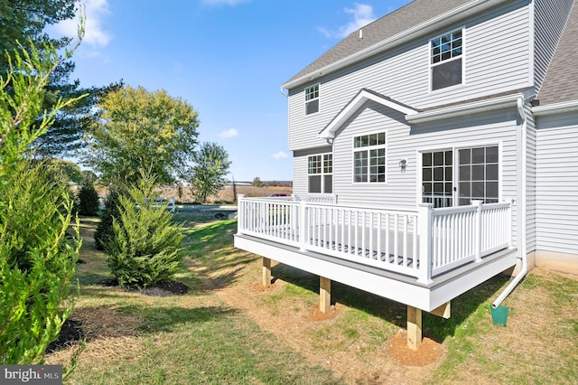 rear view of house featuring a yard and a deck