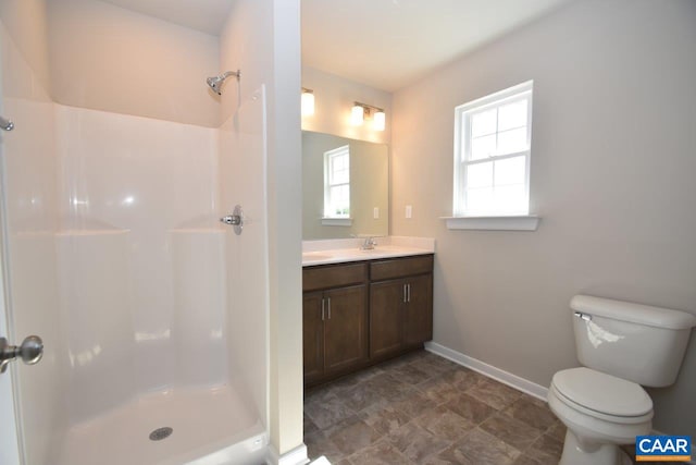 bathroom featuring vanity, toilet, and a shower