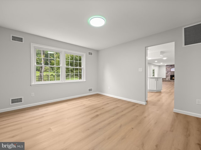 8018 Martown Rd, Laurel, MD 20723 - unfurnished room featuring light wood finished floors and a stone fireplace