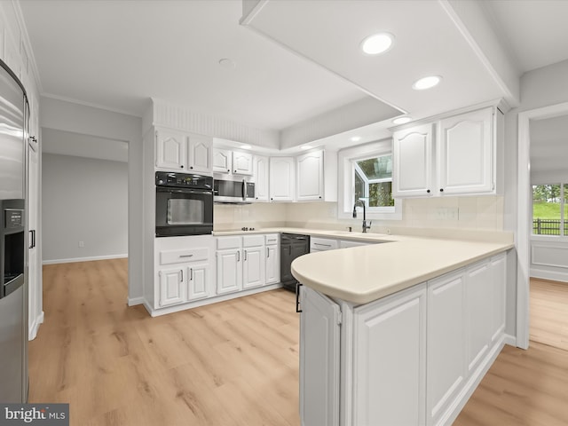 8018 Martown Rd, Laurel, MD 20723 - kitchen featuring black appliances, white cabinets, light wood-type flooring, a peninsula, and light countertops