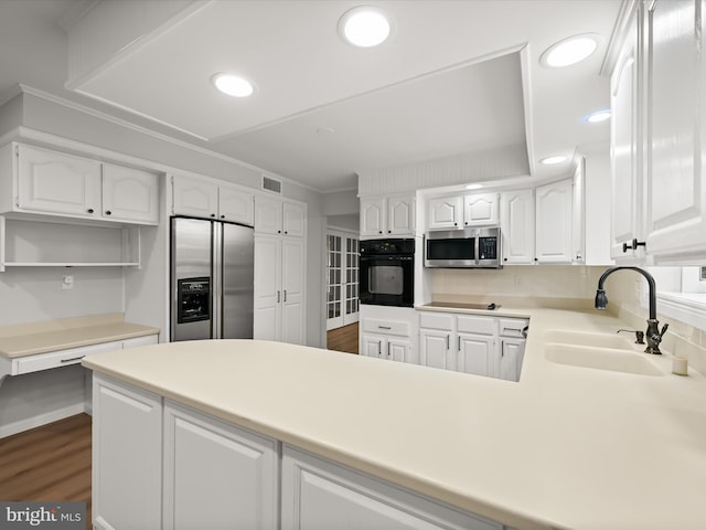 8018 Martown Rd, Laurel, MD 20723 - kitchen featuring black appliances, white cabinets, a peninsula, dark wood finished floors, and recessed lighting