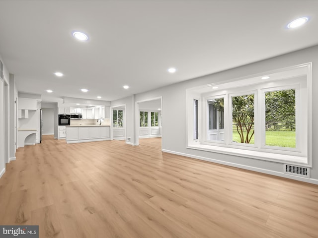 8018 Martown Rd, Laurel, MD 20723 - unfurnished living room with recessed lighting, healthy amount of natural light, and light wood-type flooring