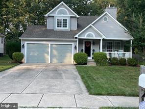 view of front facade featuring covered porch, a garage, and a front lawn