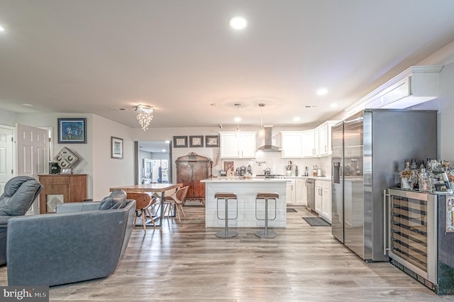 living area featuring a dry bar, wine cooler, recessed lighting, and light wood-style floors