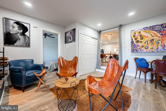 living area featuring light hardwood / wood-style flooring and ceiling fan