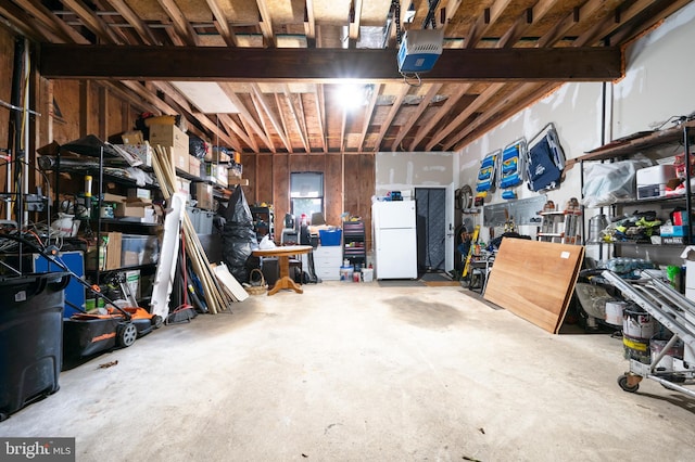basement featuring a garage and freestanding refrigerator