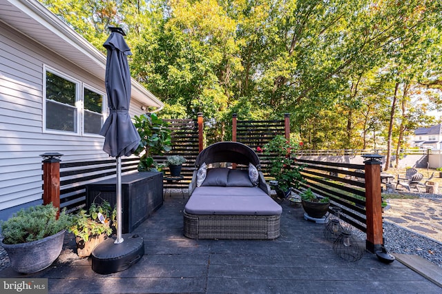 view of patio with an outdoor living space, fence, and a deck