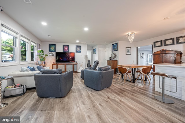 living room with light wood finished floors, visible vents, and recessed lighting