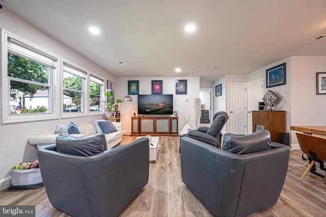 living area featuring recessed lighting, light wood-style floors, and visible vents