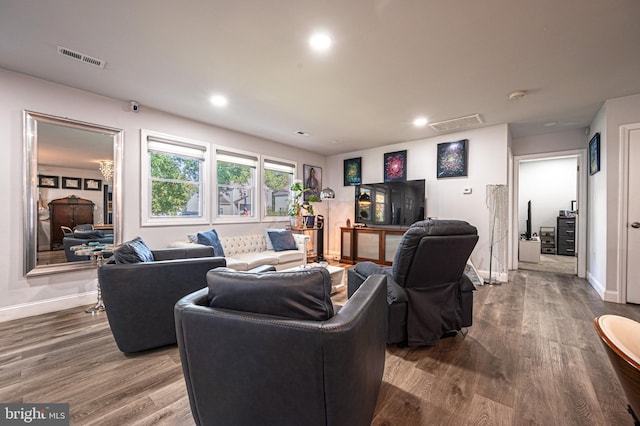 living room featuring visible vents, baseboards, and wood finished floors